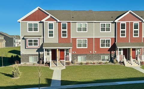 A red and grey building with a tree in front.